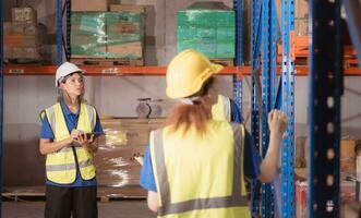 Side view of warehouse workers discussing inspecting goods brought into the warehouse for pre-stocking. photo