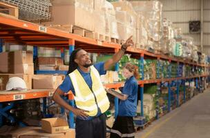 Young man and woman working together in warehouse, This is a freight transportation and distribution warehouse. Industrial and industrial workers concept photo