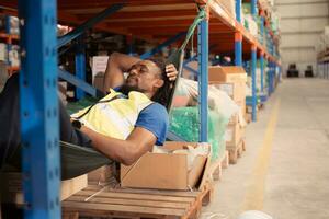 Portrait of happy mature African American man relaxing in hammock in warehouse photo