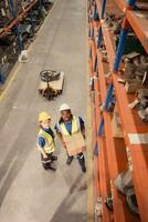 High angle view of warehouse workers in hardhats lifting boxes at warehouse photo