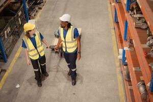 Top view of two warehouse workers pushing a pallet truck in a shipping and distribution warehouse. photo