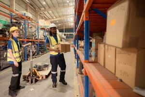 Top view of two warehouse workers pushing a pallet truck in a shipping and distribution warehouse. photo