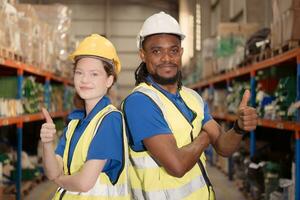 Portrait of confident warehouse staff standing with thumb up in a warehouse photo
