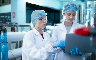 Two young female scientists working with tablet computer in drinking water plant photo