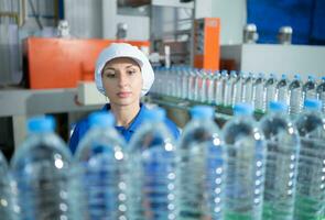 Bebiendo agua fábrica trabajador a un producción línea de Bebiendo agua fábrica foto