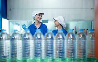 Drinking water factory worker at a production line of drinking water factory photo