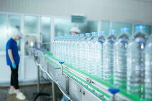 Bebiendo agua fábrica trabajador a un producción línea de Bebiendo agua fábrica foto