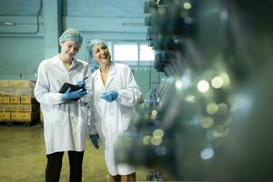 Both of female quality control workers in a drinking water factory Inspecting the quality of water tanks before importing the drinking water belt into the tank photo