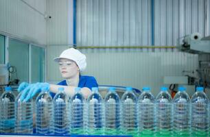 Bebiendo agua fábrica trabajador a un producción línea de Bebiendo agua fábrica foto