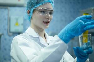 Portrait of confident female researcher carrying out scientific experiment in drink water laboratory photo