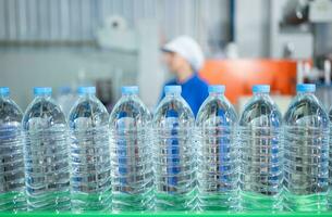 Drinking water factory worker at a production line of drinking water factory photo