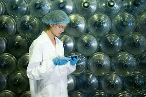 Female researcher carrying out scientific research in drinking water factory photo