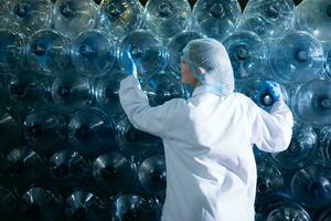 Portrait of Female scientist with arms crossed in drinking water factory, She was standing in front of a plastic bottle. photo