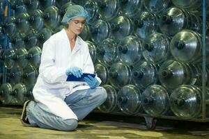 Female researcher carrying out scientific research in drinking water factory photo