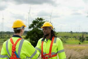 Engineer and technician discussing a solution problem of wind turbine before go in and check wind turbine, The concept of natural energy from wind. photo