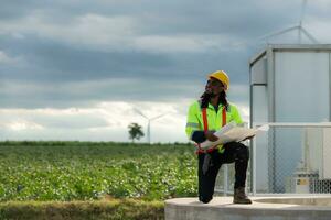 Engineer working in front of wind turbines on a cloudy day, The concept of natural energy from wind. photo