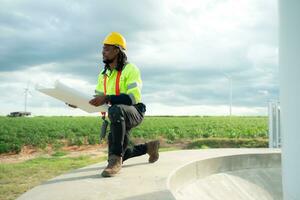 Engineer working in front of wind turbines on a cloudy day, The concept of natural energy from wind. photo