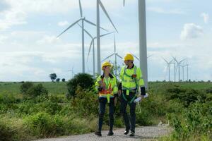 Engineers and wind turbines in a wind farm in the countryside with daily audit tasks mission photo