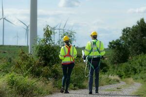 ingenieros y viento turbinas en un viento granja en el campo con diario auditoría Tareas misión foto