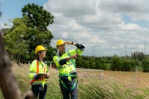 Engineer and worker discussing the project on the background of wind turbines photo