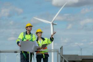 Engineer and technician discussing a solution problem of wind turbine before go in and check wind turbine, The concept of natural energy from wind. photo