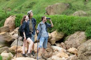 Group of tourists with backpacks walking on the trail in the river and mountains photo