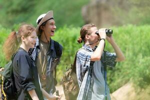 Group of tourists with backpacks walking on the trail in the river and mountains photo