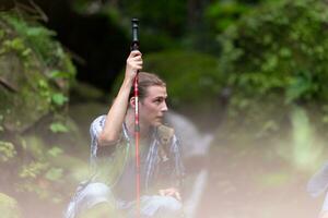 grupo de joven personas excursionismo en el bosque. viaje y aventuras concepto. foto