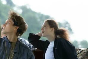 A young couple sits on a boat for a journey into the forest above the dam for trekking. photo