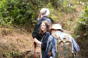 Group of friend on a sunny day in the forest Young group hiker with backpack and trekking poles photo