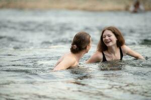 Young couple having fun in the water of a river on a hot summer day photo