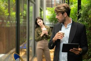 Both of businessperson using digital tablet at outdoor cafe. Business people meeting in coffee shop. photo