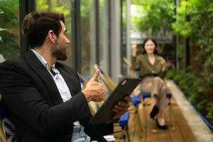 Both of businessperson using digital tablet at outdoor cafe. Business people meeting in coffee shop. photo