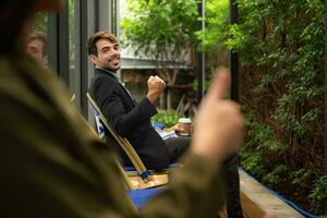 Both of businessperson using digital tablet at outdoor cafe. Business people meeting in coffee shop. photo