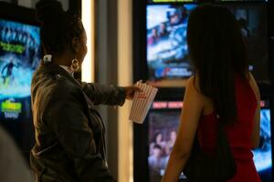 Both of young woman stand and watch the movie program to watch today. photo