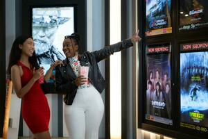 Both of young woman stand and watch the movie program to watch today. photo