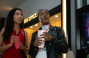 Both of young woman stand and watch the movie program to watch today. photo