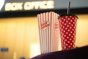 Popcorn and drinking glass a companion item of people for watching movies in the cinema. photo