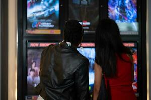 Both of young woman stand and watch the movie program to watch today. photo