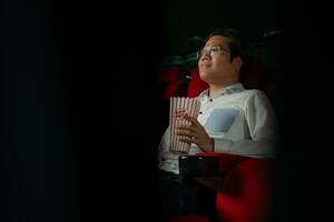 cine concepto. personas acecho película a cine bebida agua y comiendo palomitas de maiz foto