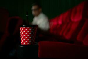 Cinema concept. People watching movie at cinema drink water and eating popcorn photo