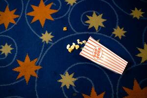 Popcorn and film strip on the blue background. photo