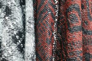 Detailed close up view on samples of cloth and fabrics in different colors found at a fabrics market photo