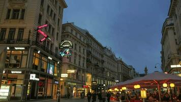 Timelapse of evening city with walking people, cafes, buildings and shops video