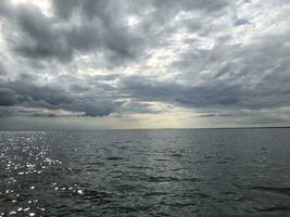 seascape, dramatic low dark clouds over the sea, dark sea, horizon photo