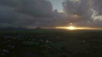 Aerial view of Mauritius Island, forests, farm, fields and hills against sunset sky and pink clouds video