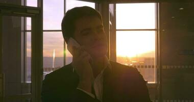 homme dans le aéroport ayant une téléphone parler à le coucher du soleil video