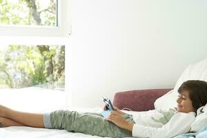 Small happy boy enjoys his last days of vacation, with his tablet, days before going back to school photo