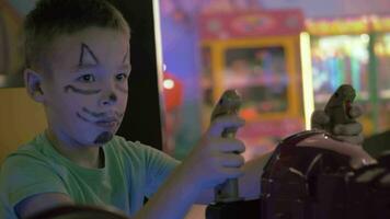 ein Junge mit ein gemalt Katze Schnauze auf ein Gesicht spielen ein Spiel Maschine video