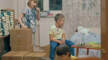 grupo de niños jugando entre cajas a hogar video